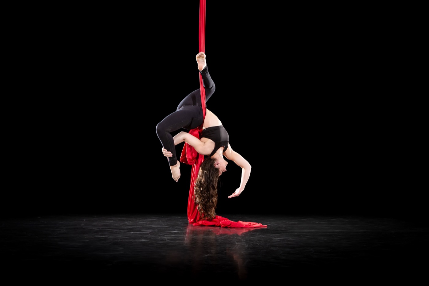 Body Lab aerialist performing on red silks